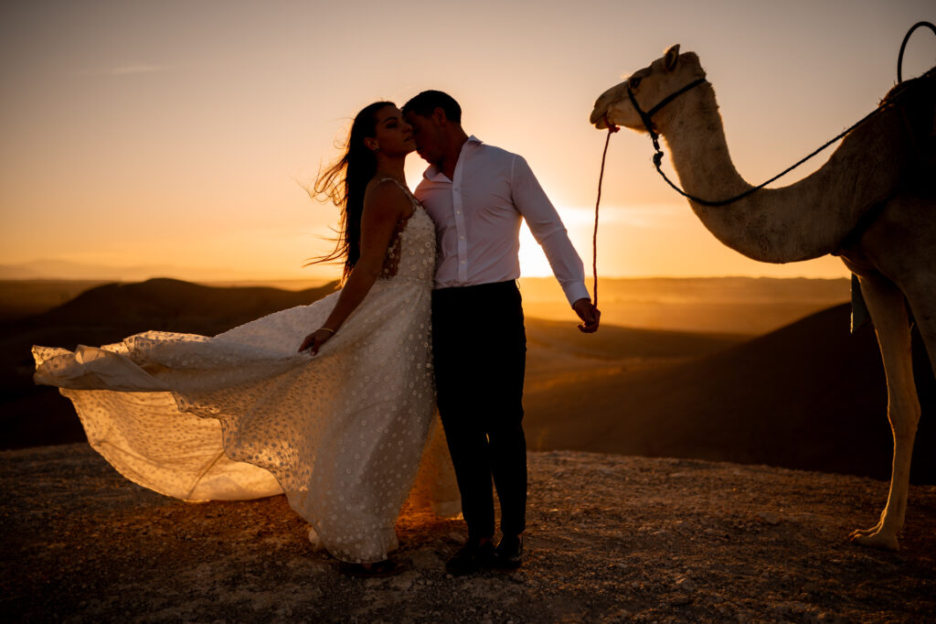 couple de mariés avec un dromadaire au coucher de soleil dans le désert d'Agafay à Marrakech