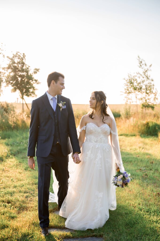 Les yeux dans les yeux, les mariés marchent ensemble au domaine de Vaujoly